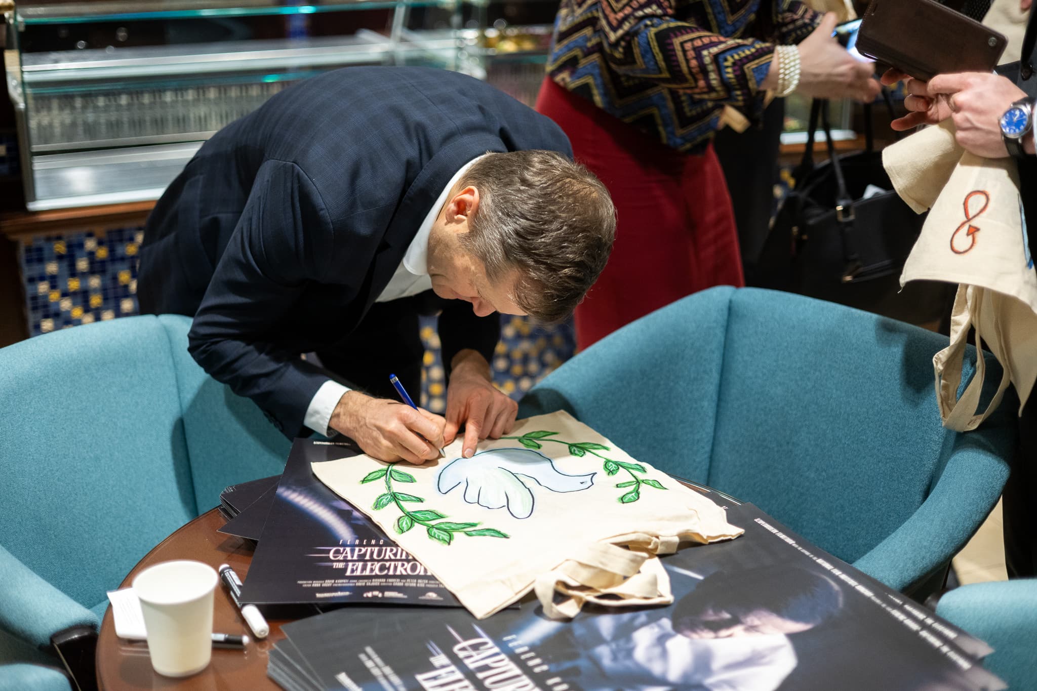 Ferenc Krausz signing a hand-painted canvas bag