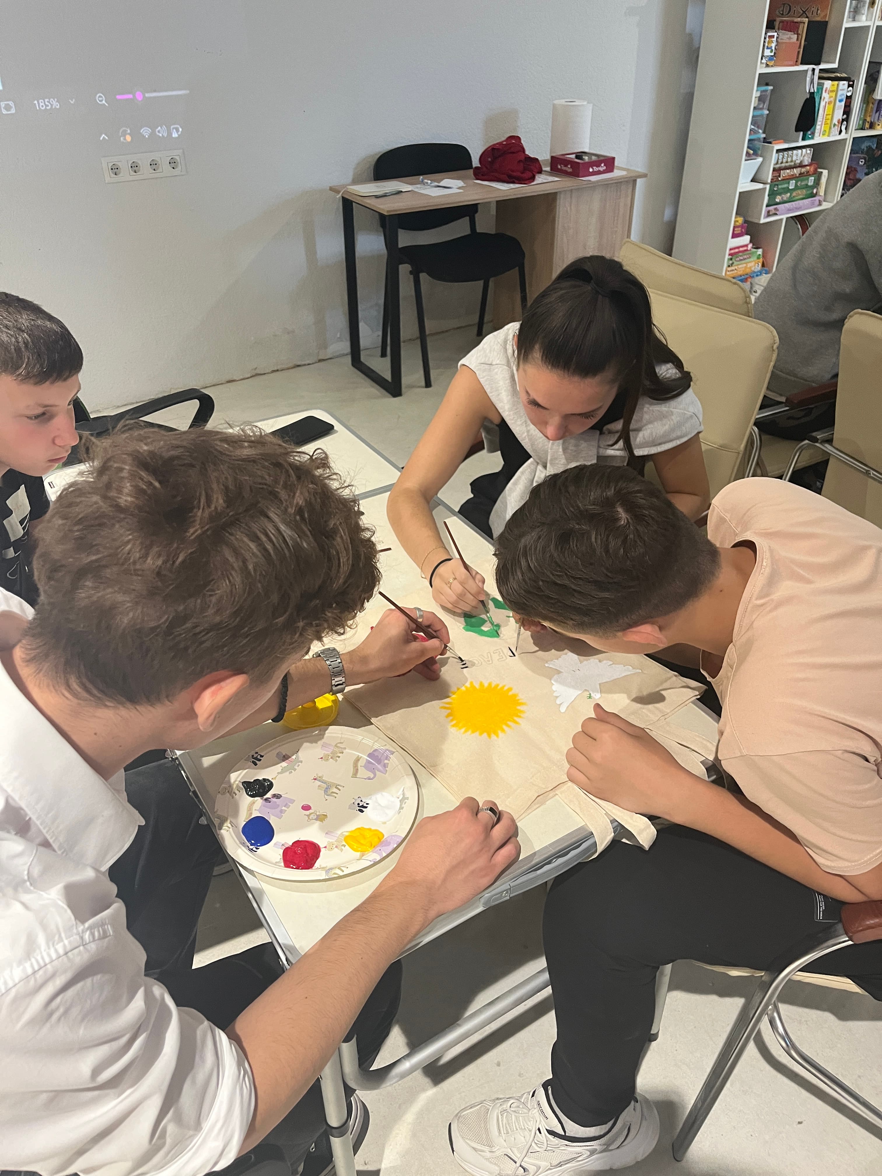 Youth painting on canvas bags together